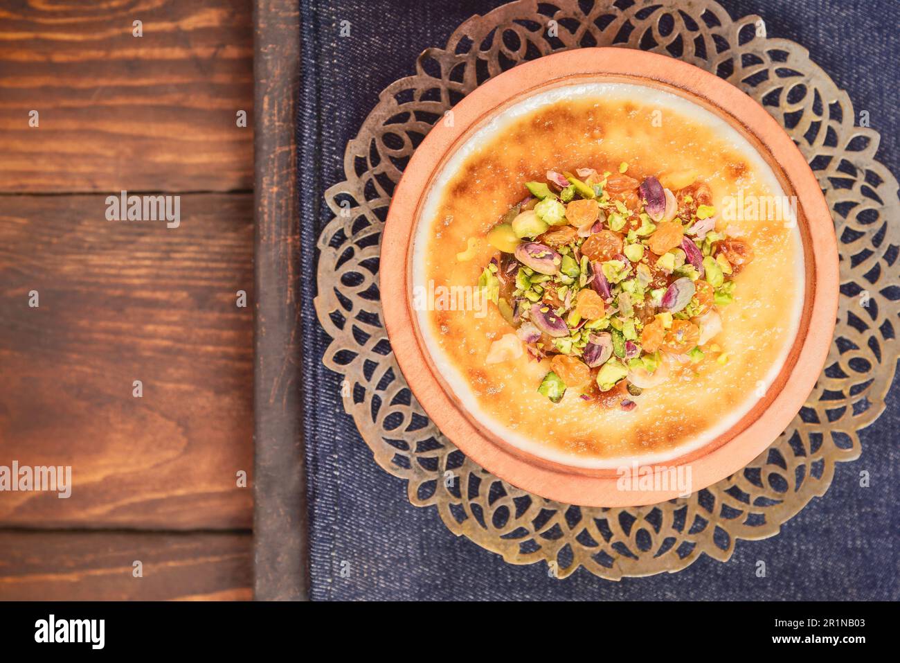 Arabische Küche; traditionelles ägyptisches Dessert „Om Ali“ oder „Umm Ali“ mit eingeweichten Broten, Milch und einer Ladung gerösteter Nüsse und Rosinen. Draufsicht mit Nahaufnahme. Stockfoto