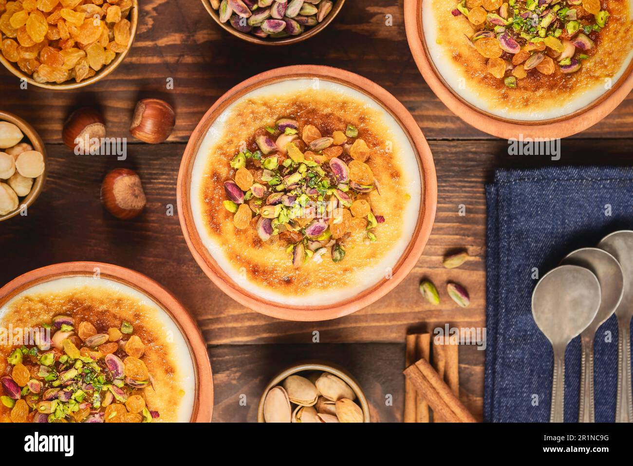 Arabische Küche; traditionelles ägyptisches Dessert „Om Ali“ oder „Umm Ali“ mit eingeweichten Broten, Milch und einer Ladung gerösteter Nüsse und Rosinen. Draufsicht mit Nahaufnahme. Stockfoto