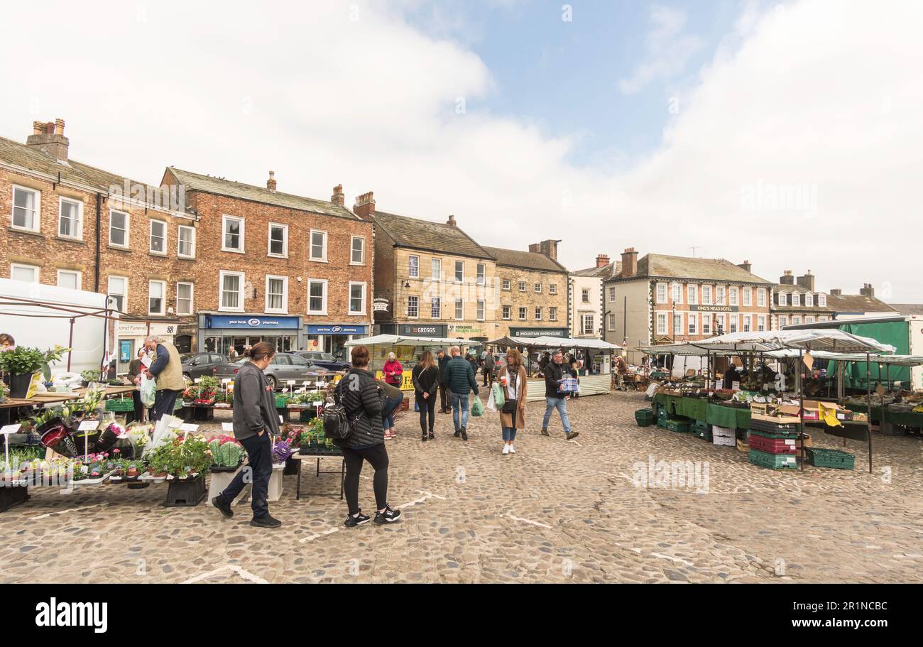 Leute, die in Richmond Outdoor Market, Market Place, Richmond, North Yorkshire, England einkaufen, UK Stockfoto