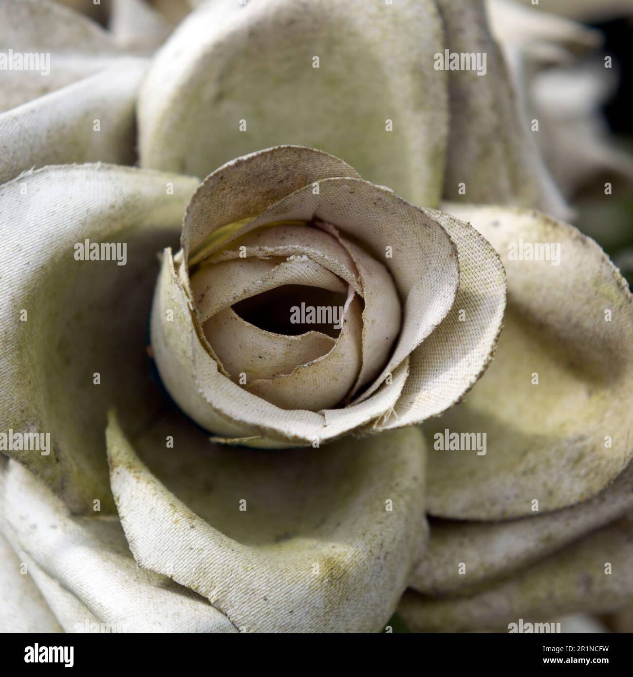 Eine verblasste künstliche Blume auf einem Grab. Stockfoto