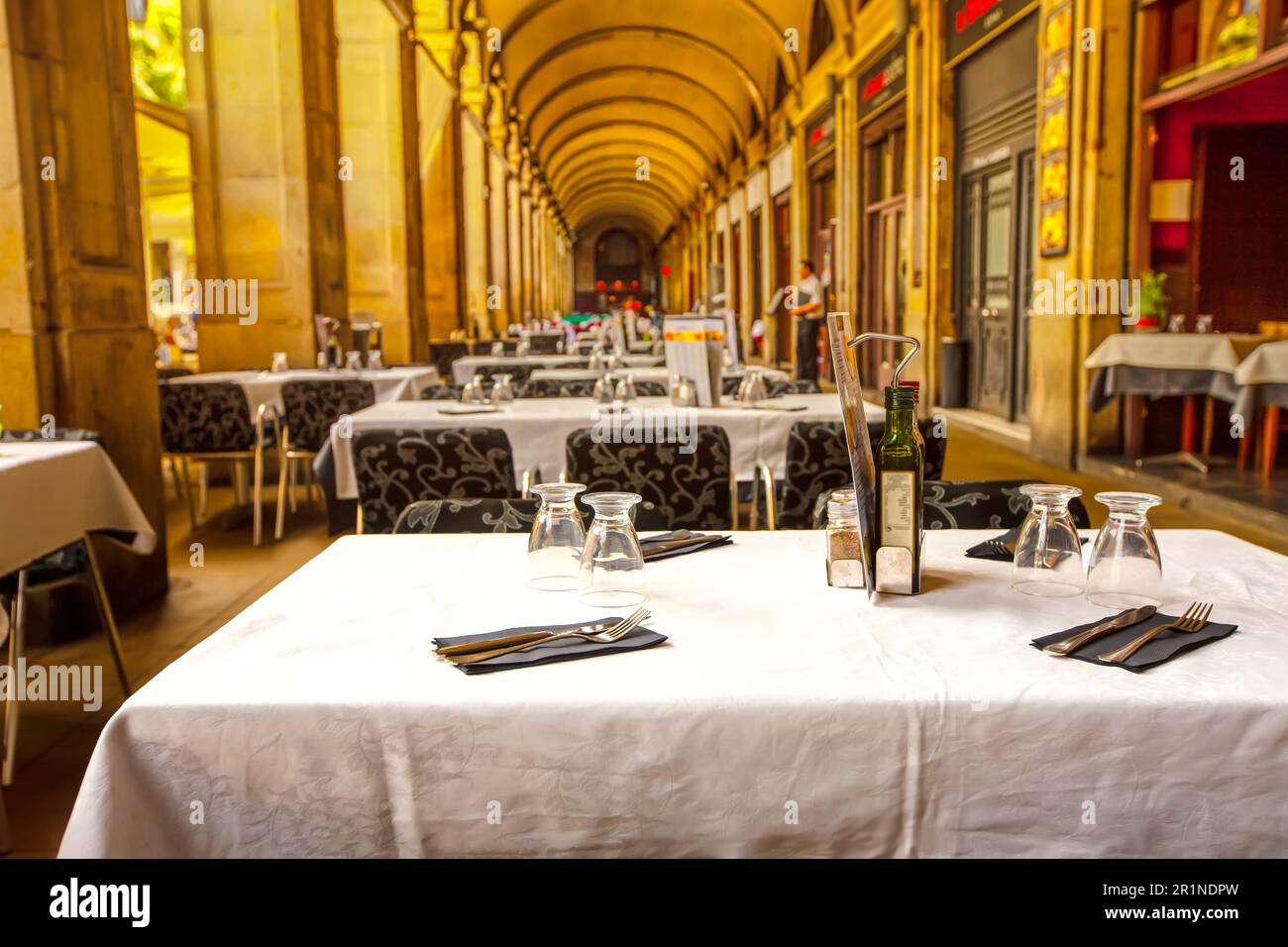 Leeres Straßencafé im Sommer mit überdachten weißen Tischen in barcelona Stockfoto