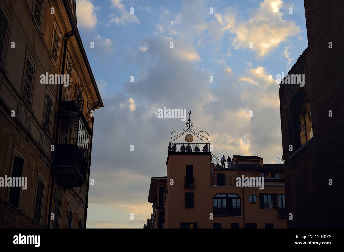 Balkon auf dem Dach eines Gebäudes, neben anderen Gebäuden mit einem Sonnenuntergangshimmel im Hintergrund Stockfoto