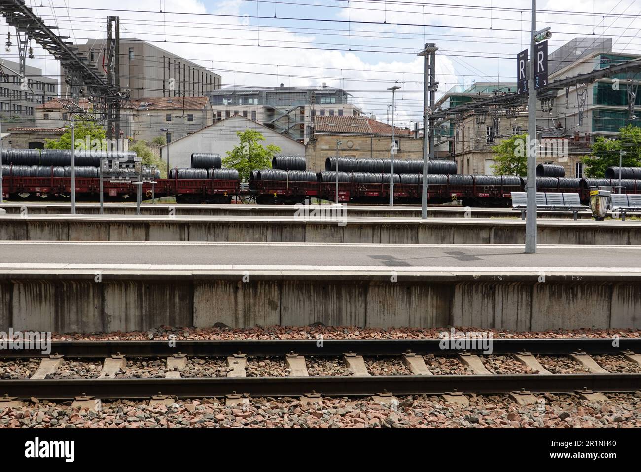 Leere Bahnsteige und Gleise am Bahnhof Bordeaux-Saint-Jean, während der Güterzug durch die Infrastruktur fährt, Bordeaux, Frankreich. Stockfoto