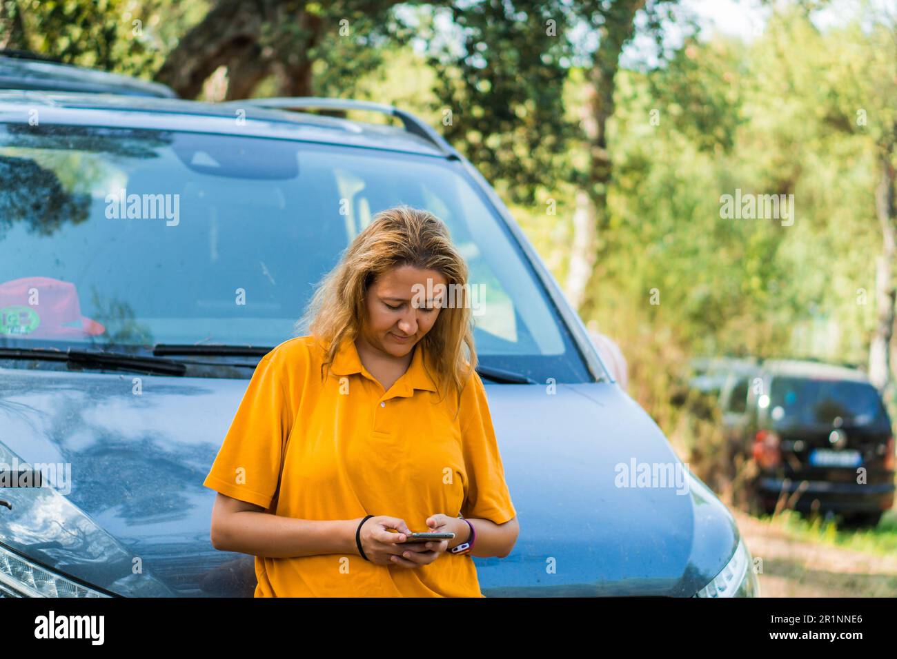 Hübsche blonde Frau, die auf das Smartphone schaut Stockfoto