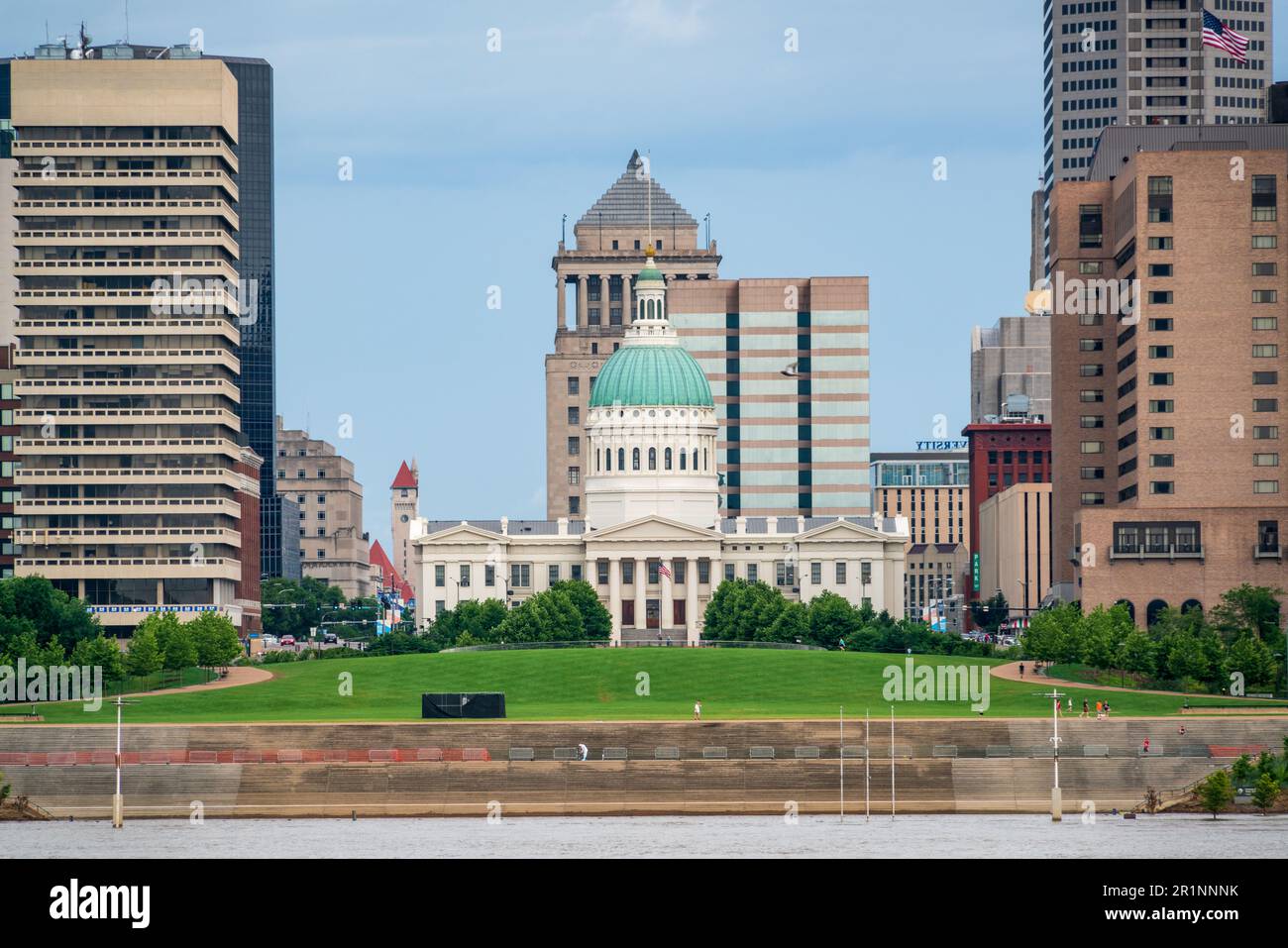 Das Old Courthouse mit seiner grünen Kuppel steht hinter einem Flussuferrasen und Bürotürmen auf der anderen Flussseite, Gateway Arch National Park, Missouri. Stockfoto