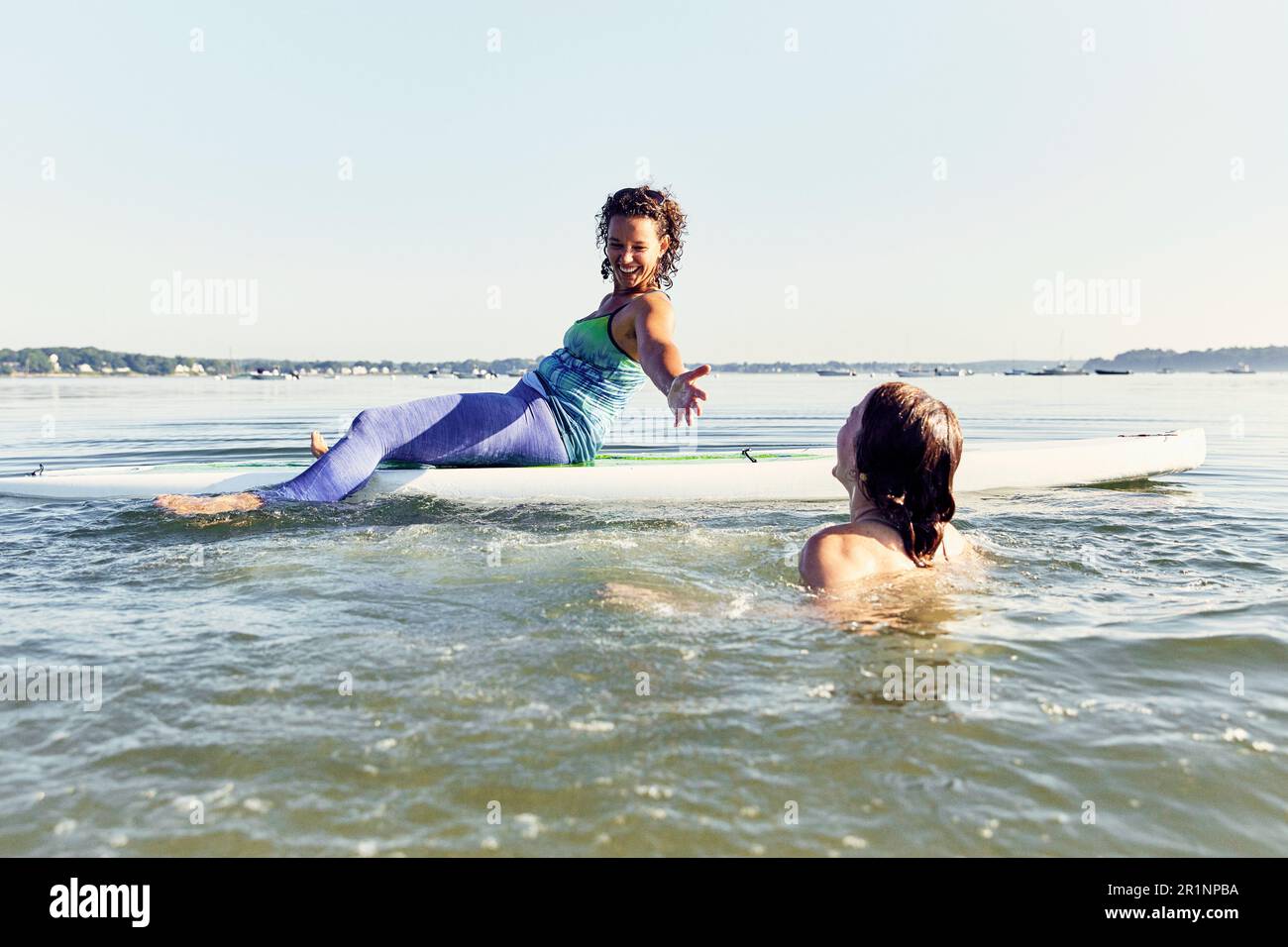 Zwei junge Freundinnen auf dem Stand-up-Paddle-Board in Casco Bay, Maine Stockfoto