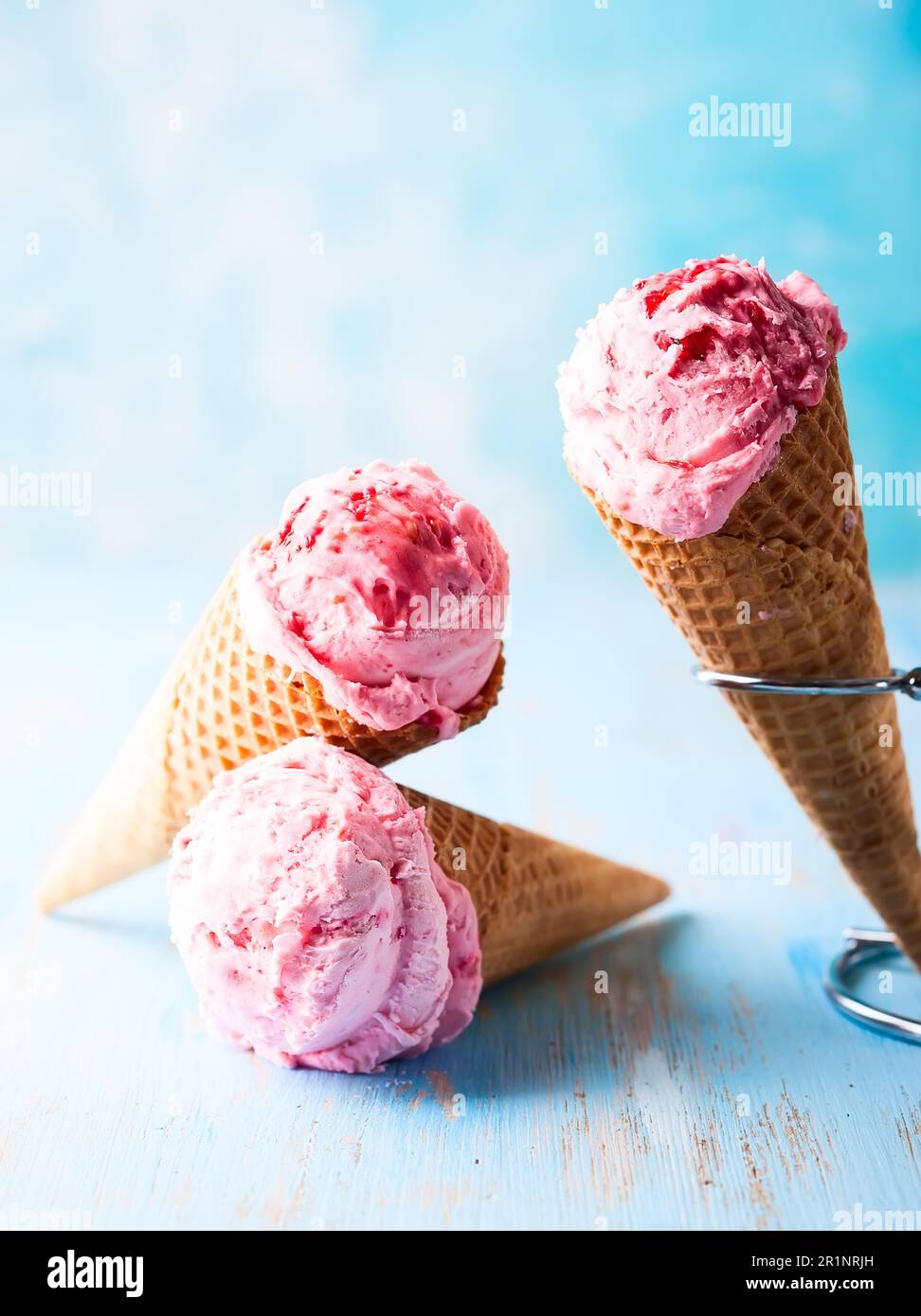 Eiscreme mit Himbeere in Waffel auf blauem Hintergrund Stockfoto