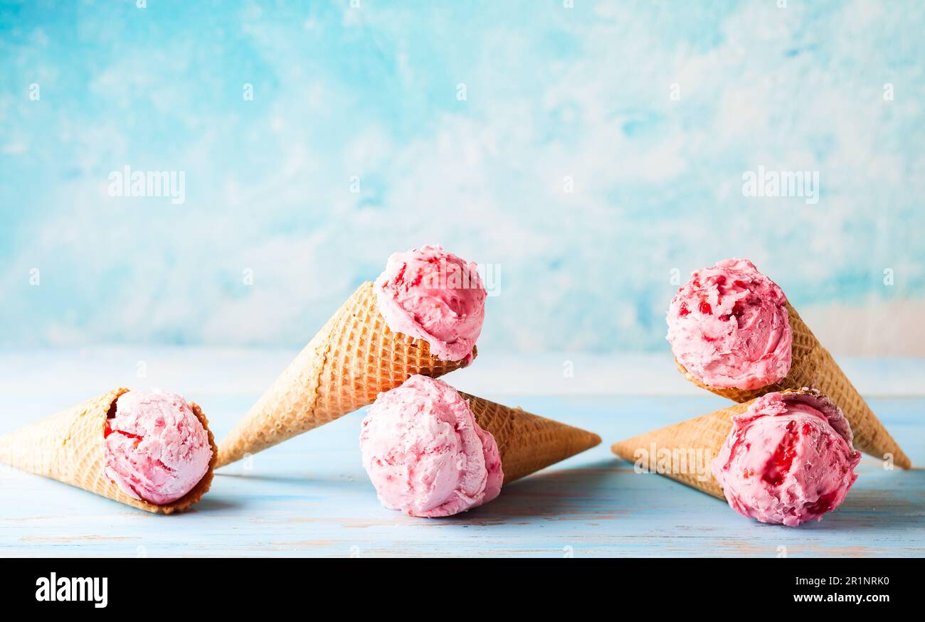 Eiscreme mit Himbeere in Waffel auf blauem Hintergrund Stockfoto