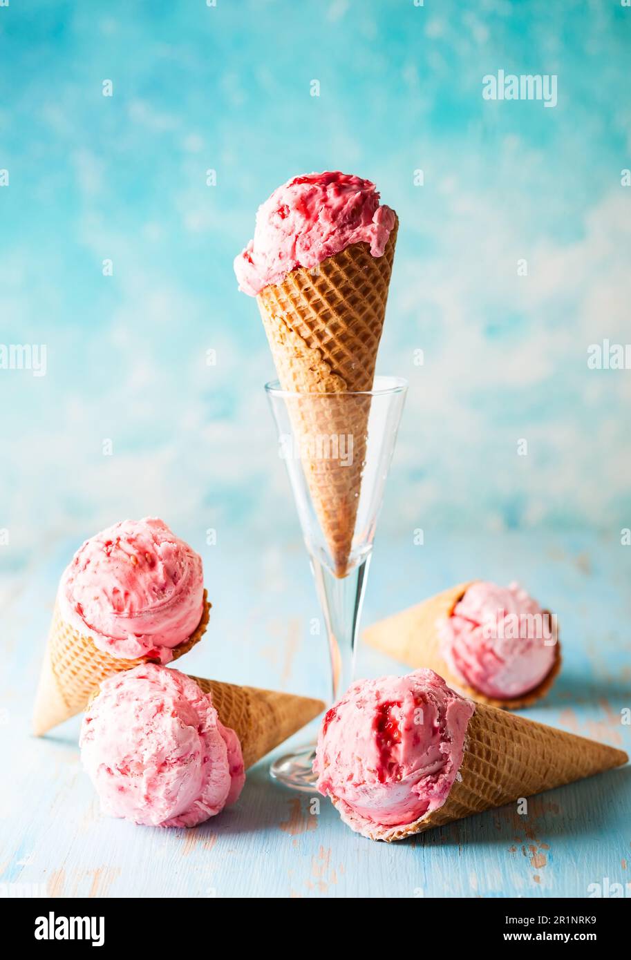 Eiscreme mit Himbeere in Waffel auf blauem Hintergrund Stockfoto