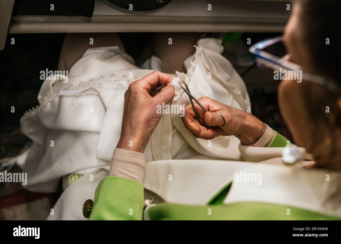 Nahaufnahme von Schneiderin mit Schere in ihrer Nähwerkstatt Stockfoto