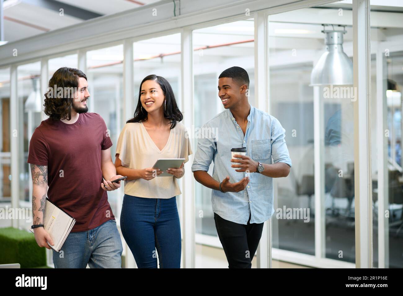 Innovation ist der Katalysator für den Erfolg ihrer Teams. Eine Gruppe von Geschäftsleuten, die eine Diskussion führen, während sie gemeinsam durch ein Büro gehen. Stockfoto