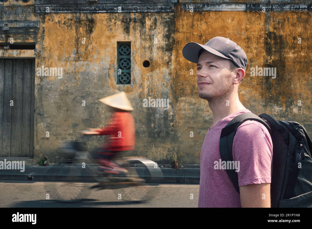 Porträt eines Reisenden mit Rucksack. Ein Mann erkundet die Straßen der antiken Stadt Hoi an in Vietnam. Stockfoto