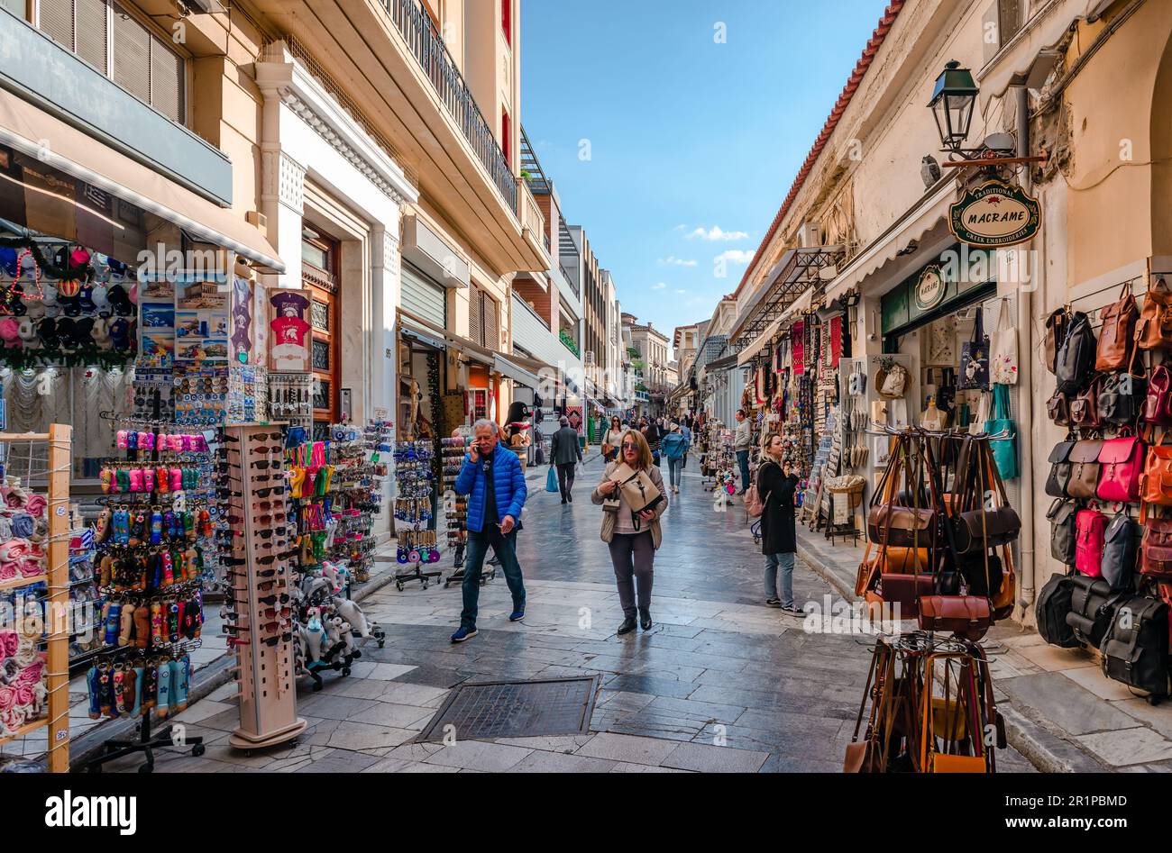 Athen, Griechenland - Januar 7 2023: Adrianou Street in Plaka, eine geschäftige Fußgängerzone mit Geschäften und Straßenbahnen, Cafés. Stockfoto