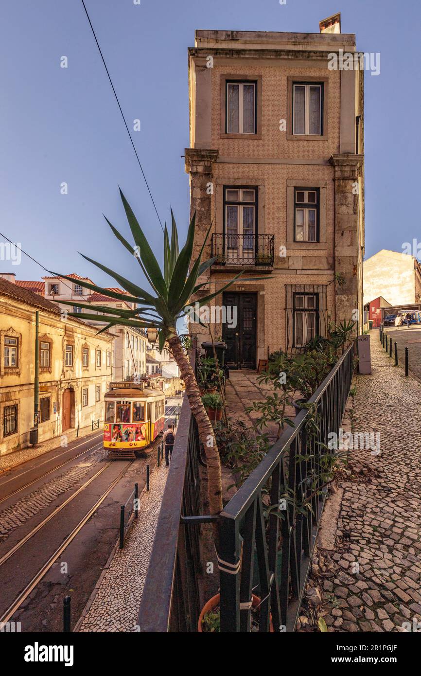 Die berühmte Straßenbahn 28, hier verläuft die Straßenbahn durch die Altstadt von Alfama, einem Viertel mit alten Gebäuden und Gassen in Lissabon, Portugal Stockfoto