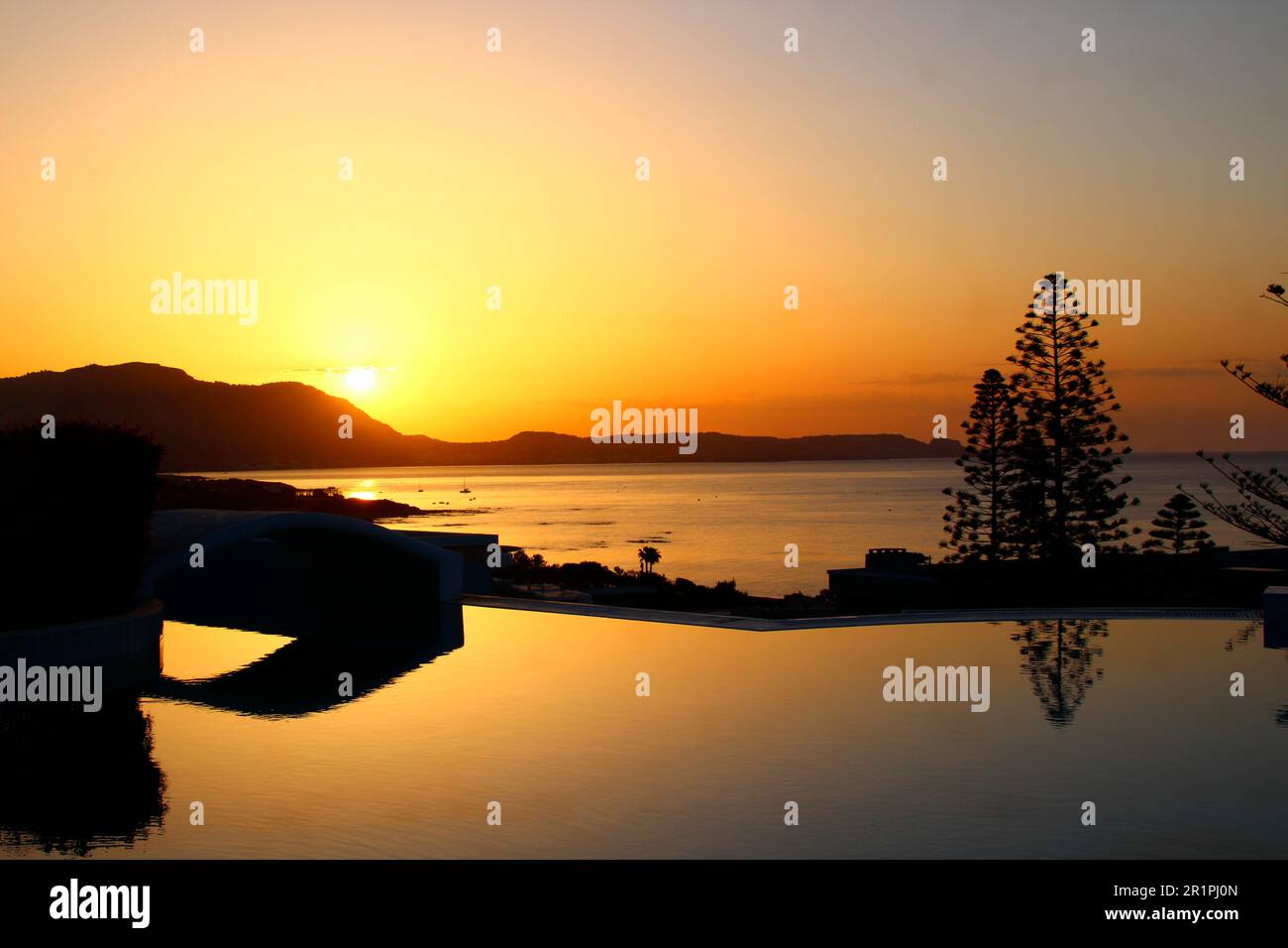 Blick auf den Sonnenaufgang, im Vordergrund Swimmingpool, Pool, Baum, Strand, Ufer, Sea, Kiotari, Rhodos, Griechenland Stockfoto
