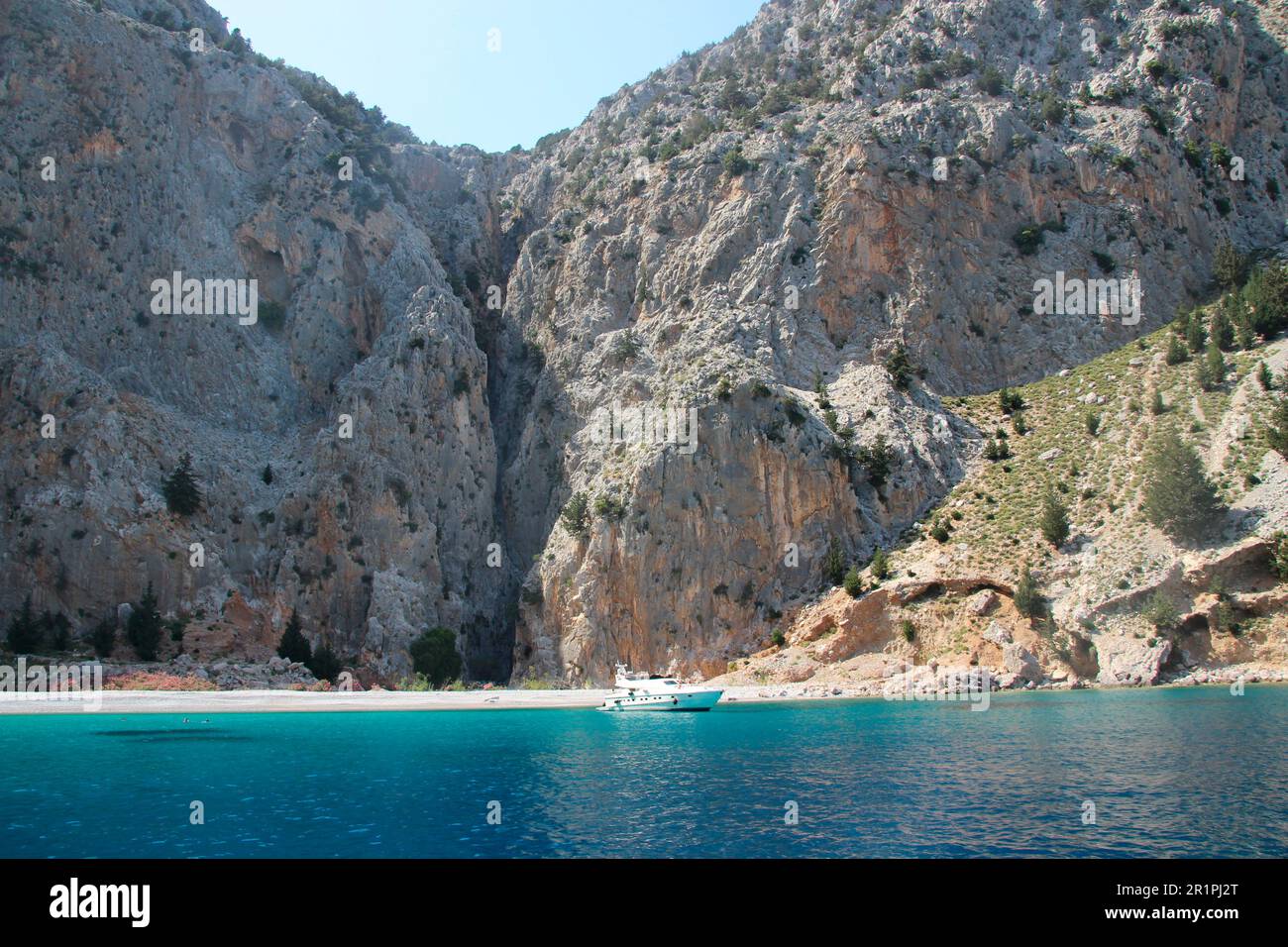Wunderschöne Bucht mit Yacht auf dem Weg von Rhodos nach Symi, türkisfarbenes Wasser, blauer Himmel, Strand Stockfoto