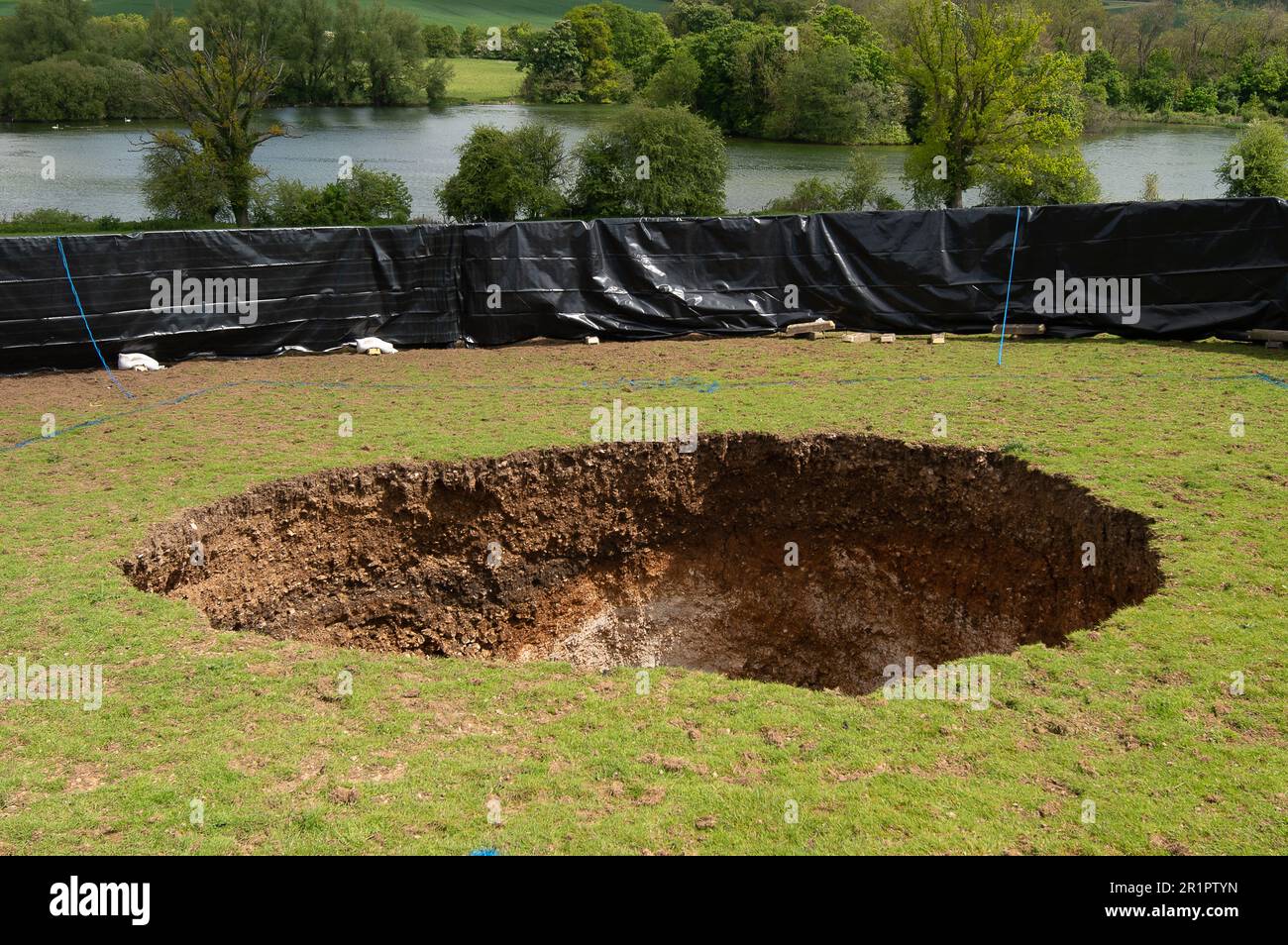 Amersham, Buckinghamshire, Großbritannien. 15. Mai 2023. Ein großes Sinkloch über den HS2 High Speed Rail Chiltern Tunnels erschien am Samstag neben dem Shardeloes Lake mit Blick auf das Shardeloes Manor in der Nähe von Amersham, Buckinghamshire. Beunruhigte Einwohner wurden von der Baugesellschaft HS2 Ltd informiert, dass „sie recht groß ist – etwa sechs Meter Durchmesser und fünf Meter Tiefe. Dabei handelt es sich um Näherungswerte.“ Kredit: Maureen McLean/Alamy Live News Stockfoto