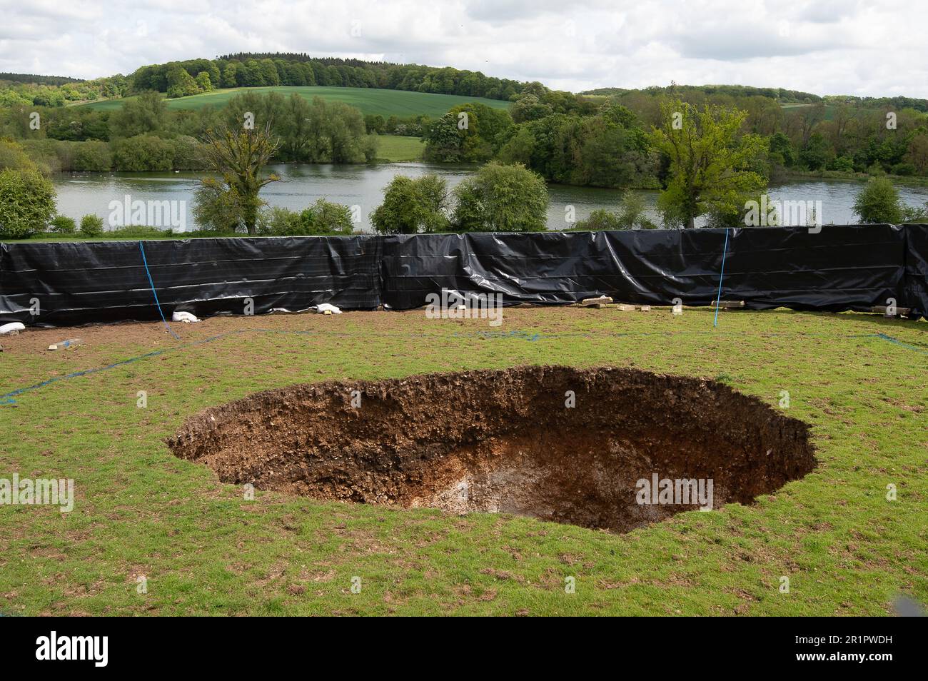 Amersham, Buckinghamshire, Großbritannien. 15. Mai 2023. Ein großes Sinkloch über den HS2 High Speed Rail Chiltern Tunnels erschien am Samstag neben dem Shardeloes Lake mit Blick auf das Shardeloes Manor in der Nähe von Amersham, Buckinghamshire. Beunruhigte Einwohner wurden von der Baugesellschaft HS2 Ltd informiert, dass „sie recht groß ist – etwa sechs Meter Durchmesser und fünf Meter Tiefe. Dabei handelt es sich um Näherungswerte.“ Kredit: Maureen McLean/Alamy Live News Stockfoto