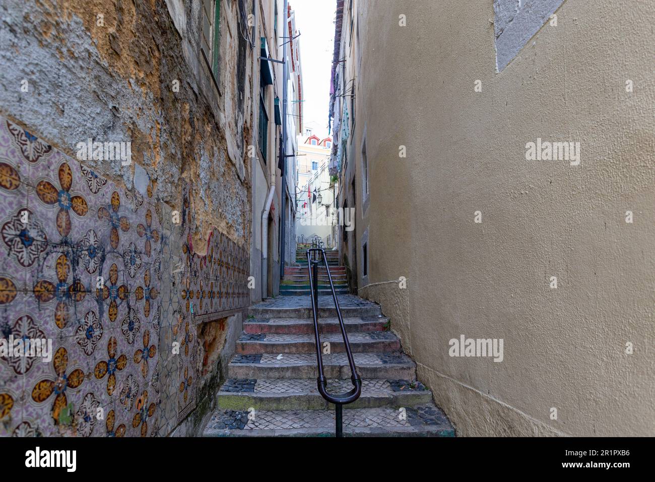 Eine enge Gasse mit Treppen im mittelalterlichen Viertel Alfama in Lissabon an einem sonnigen Tag Stockfoto