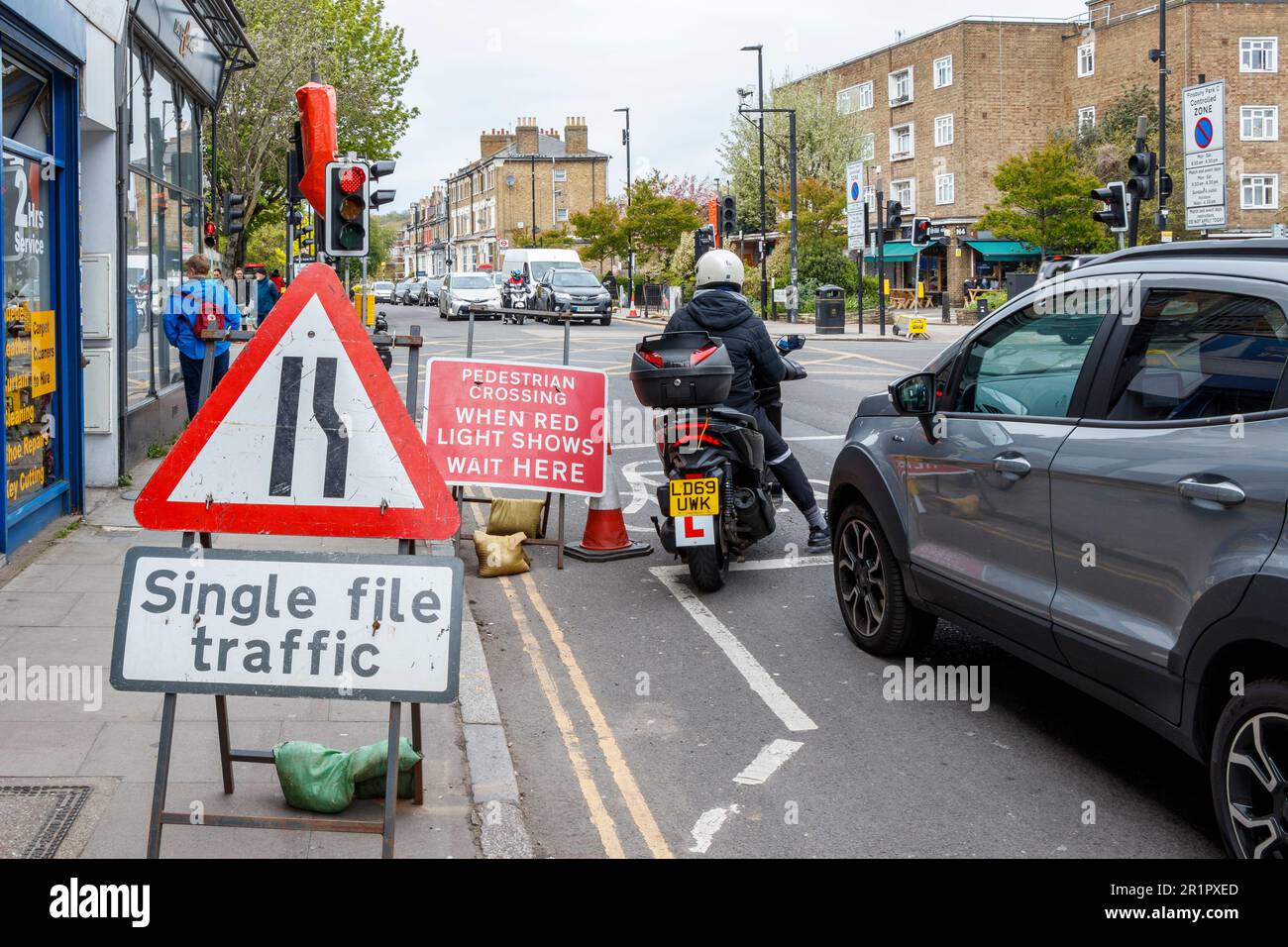 Temporäre Ampeln und einzeiliges Verkehrsschild an einer Kreuzung in Stroud Green Road, North London, Großbritannien Stockfoto