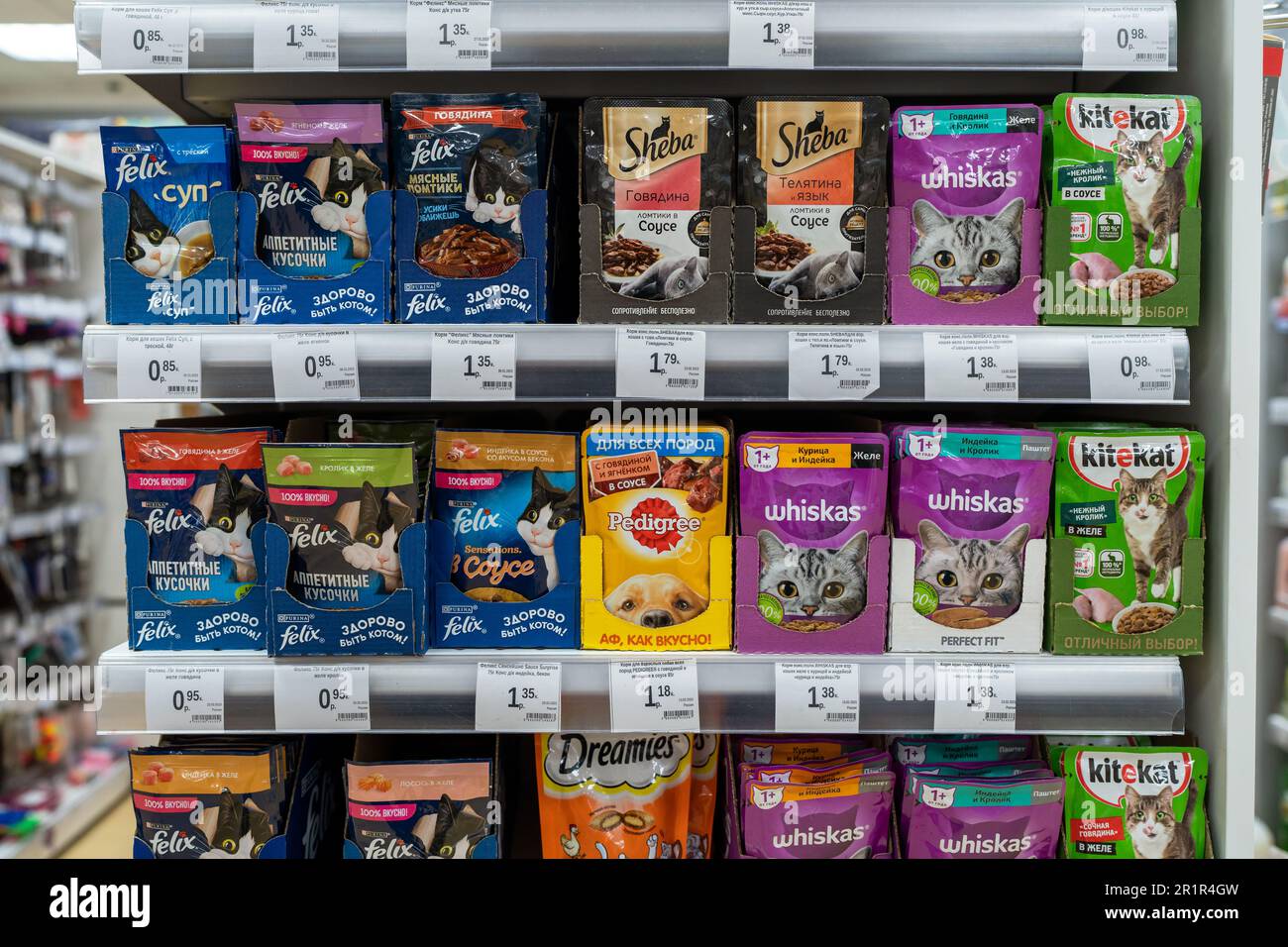 Verschiedene Arten von Futter für Katzen in Verpackungen, die im Tierhandelsregal verkauft werden, verpacktes Trockenfutter, Nassfutter in Dosen. Minsk, Weißrussland, 2023 Stockfoto