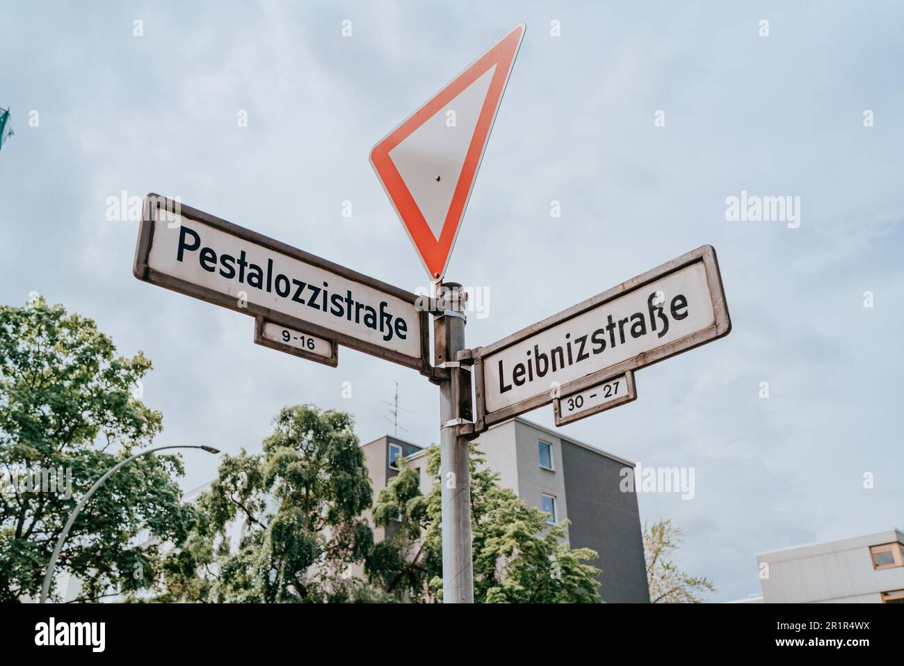 Ein Wegweiser mit einem Pfeilsymbol und Text vor einem hellblauen Himmel, das dem Fahrer Orientierung und Kommunikation bietet. Stockfoto