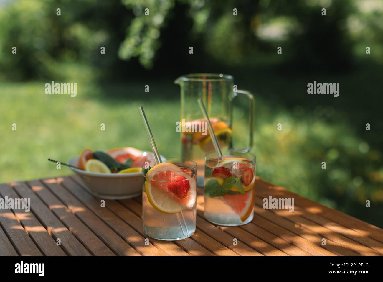 Stillleben von zwei Sommergetränken mit frischem Obst auf einem Tisch in gedämpftem Licht im Garten Stockfoto