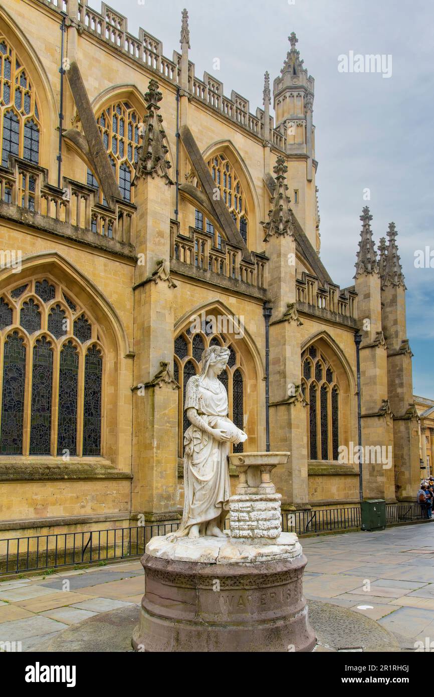 Bath, Somerset, England - August 2022; Nahaufnahme des Marmorbrunnens Rebecca entlang der Südseite der Bath Abbey mit einer Frau, die Wasser aus einem Schiff goss Stockfoto