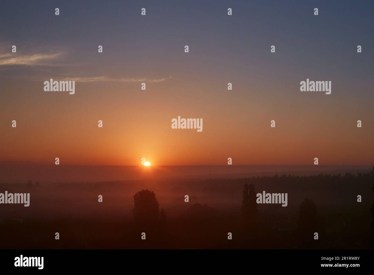 Morgenaufgang in einer nebligen orangefarbenen Landschaft Stockfoto