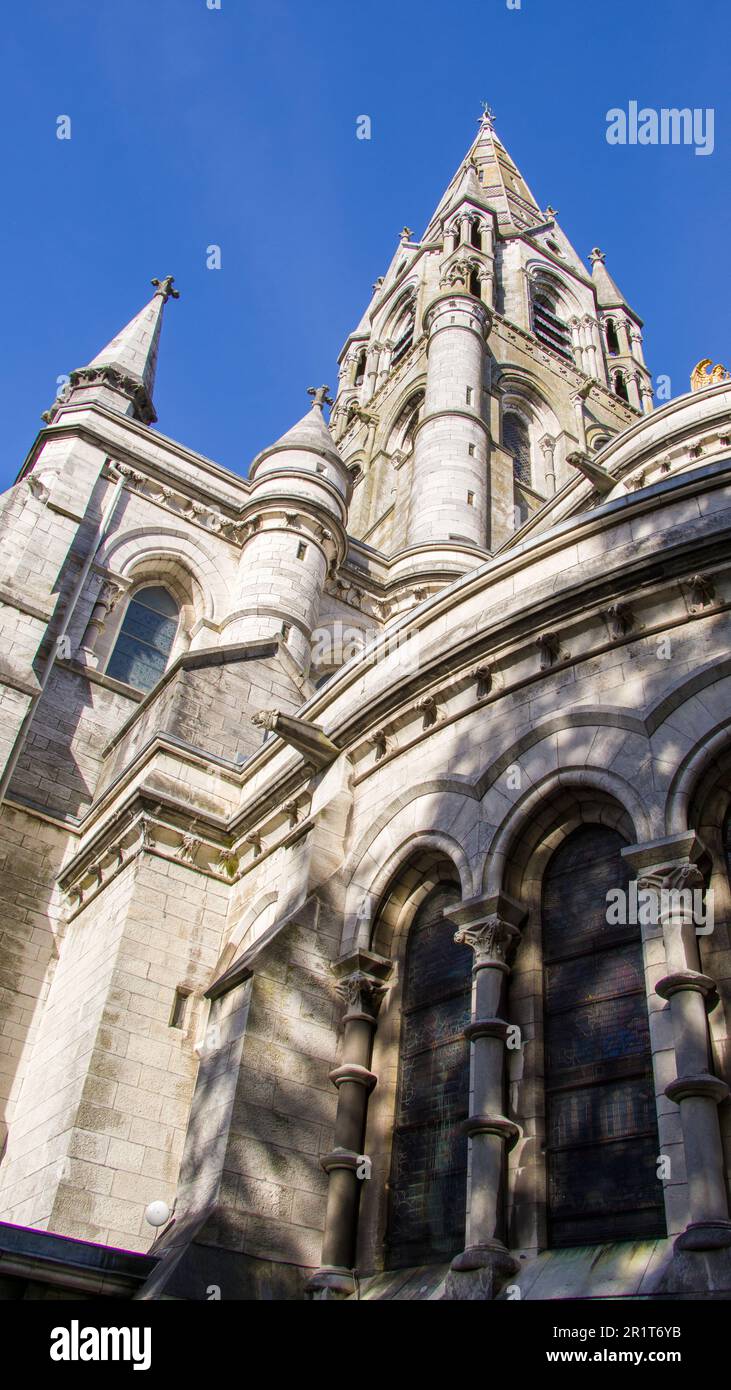 Der hohe gotische Turm einer anglikanischen Kirche in Cork, Irland. Neogotische christliche religiöse Architektur. Kathedrale St. Fin Barre, Cork - IR Stockfoto