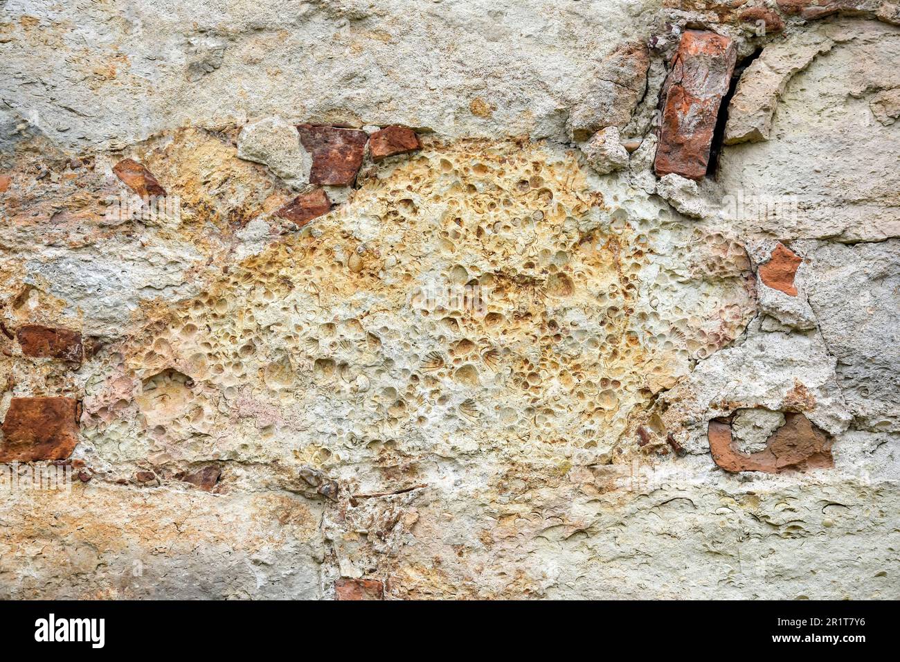 Die Konsistenz alter Steinwände mit kollabiertem Putz. Hintergrund einer schäbigen Gebäudefläche. Zerstörte Steinwand mit heruntergefallenem Gips. Verwitterte Oberfläche. Stockfoto Die Konsistenz alter Steinwände mit kollabiertem Putz. Hintergrund einer schäbigen Gebäudefläche. Zerstörte Steinwand mit heruntergefallenem Gips. Verwitterte Oberfläche. Stockfoto