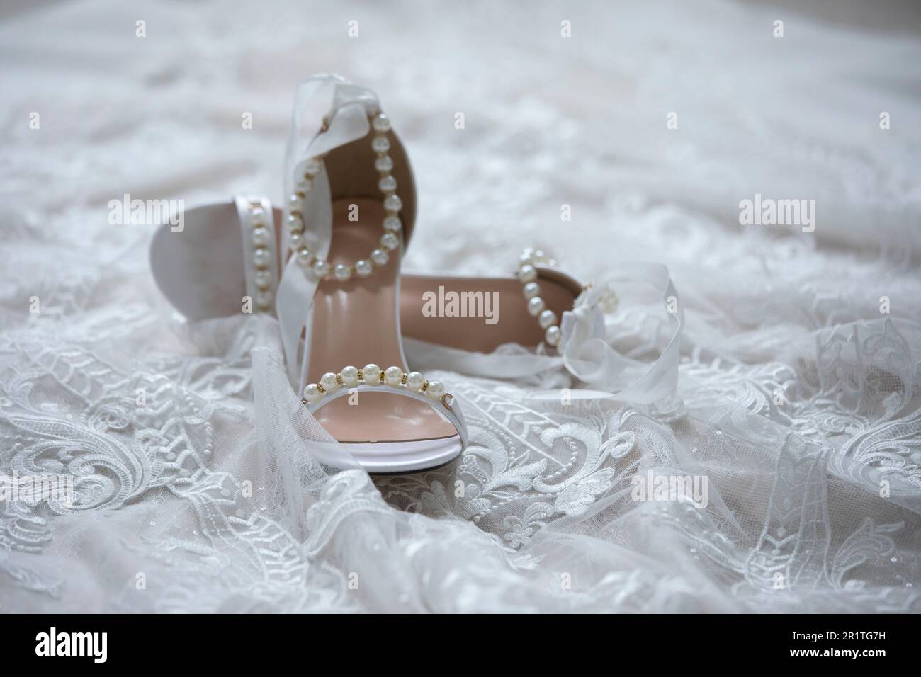 Detailaufnahme von Brautschuhen und Hochzeitskleid vor einer Hochzeit. Stockfoto