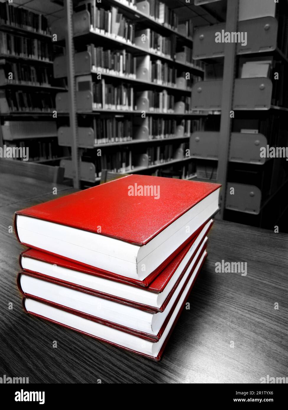Stapel alter roter Bücher auf einem Schreibtisch oder Tisch in einer Bibliothek zum Lesen und Lernen Stockfoto