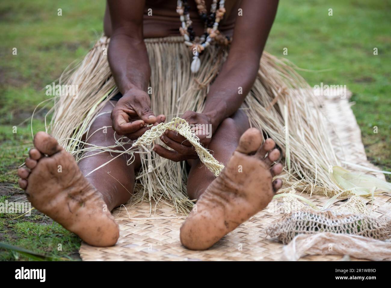 Papua-Neuguinea, Provinz Oro, Insel Tufi, Dorf Baga. Eine Frau, die Stroh webt. Stockfoto