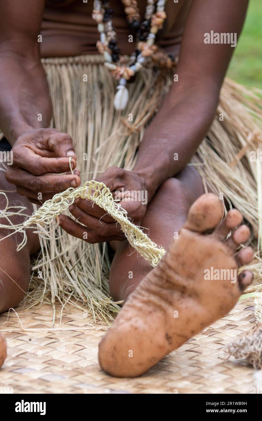 Papua-Neuguinea, Provinz Oro, Insel Tufi, Dorf Baga. Eine Frau, die Stroh webt. Stockfoto