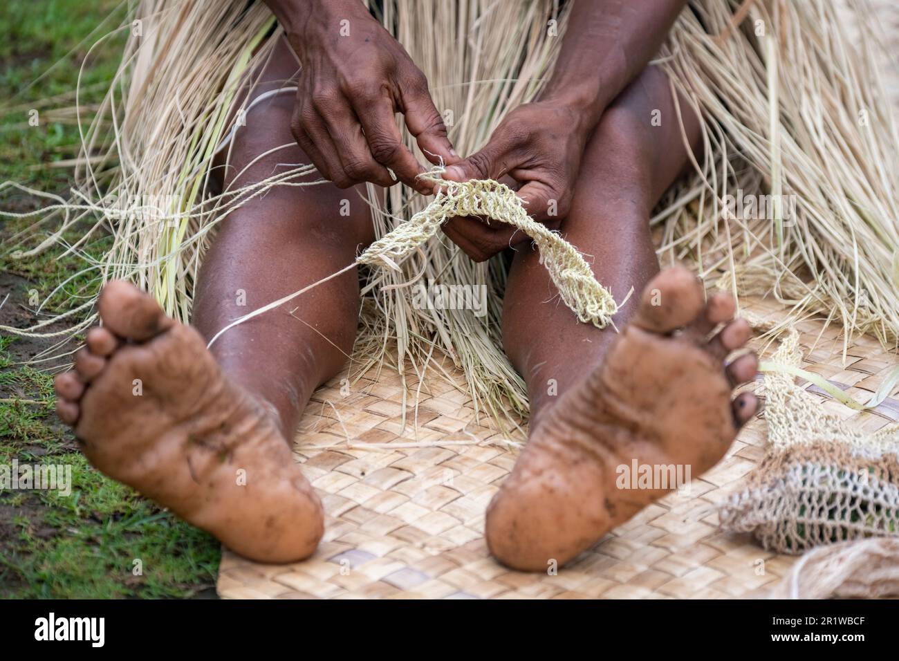 Papua-Neuguinea, Provinz Oro, Insel Tufi, Dorf Baga. Eine Frau, die Stroh webt. Stockfoto