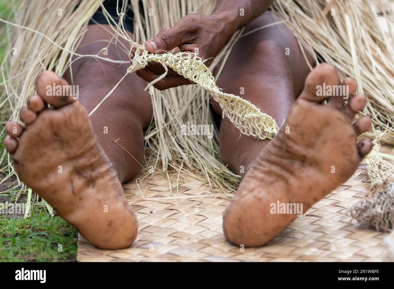 Papua-Neuguinea, Provinz Oro, Insel Tufi, Dorf Baga. Eine Frau, die Stroh webt. Stockfoto