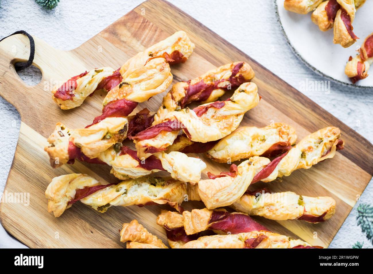 Blätterteigstöcke. Nahaufnahme von herzhaftem Blätterteig mit Prosciutto und Oliven. Idee für ein Rezept mit Vorspeisen. Hochwertiges Foto. Stockfoto