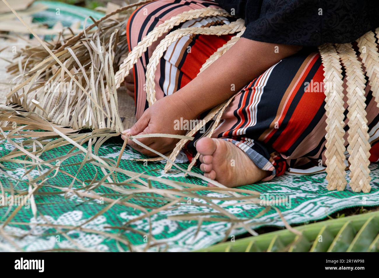 Königreich Tonga, Neiafu. Einheimische Frau, die Strohmatte webt. Stockfoto