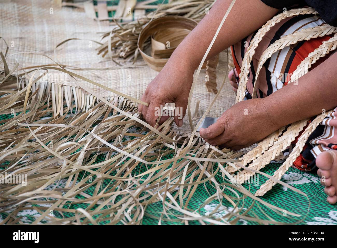 Königreich Tonga, Neiafu. Einheimische Frau, die Strohmatte webt. Stockfoto