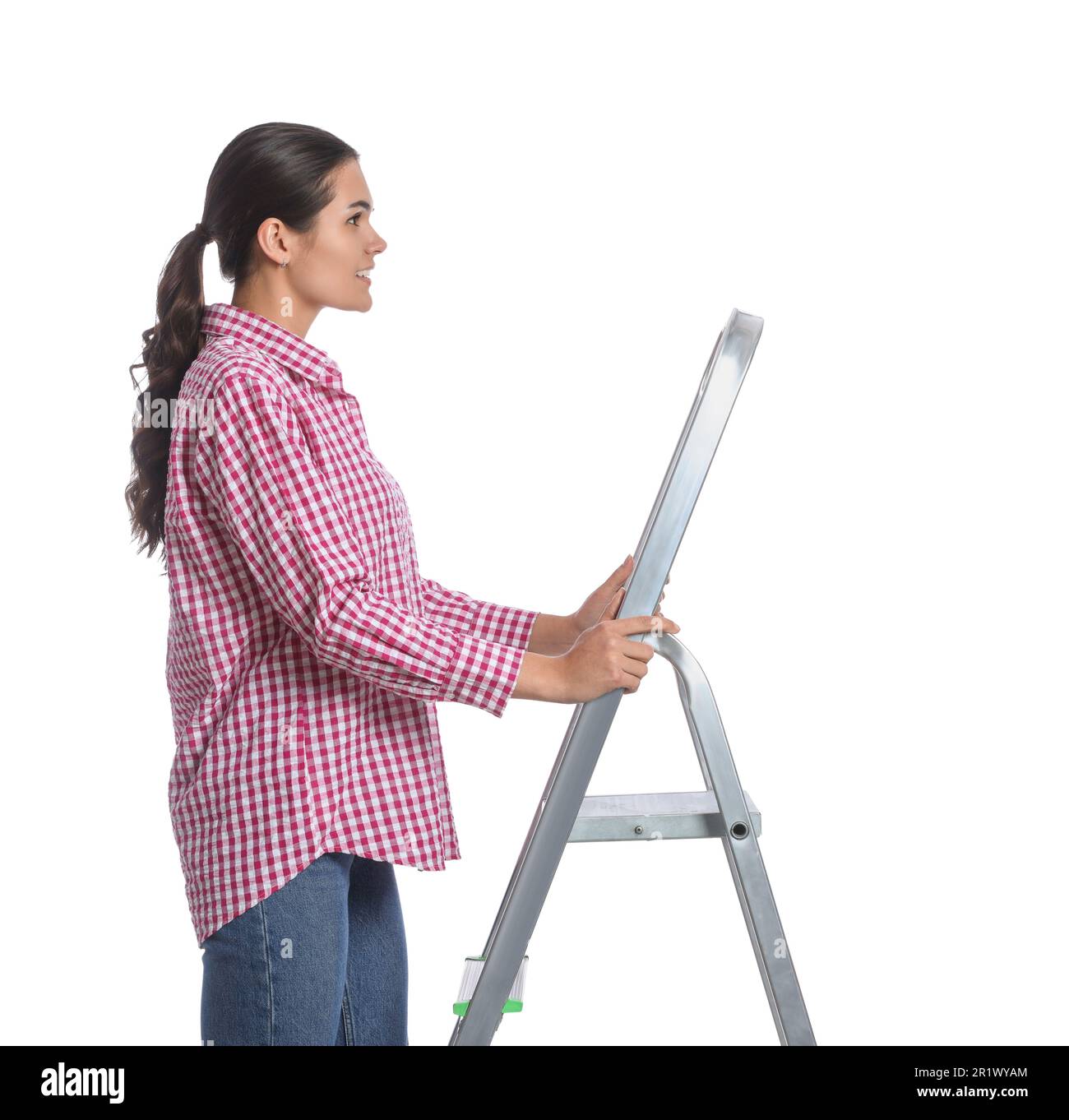 Junge Frau auf einer Metallleiter vor weißem Hintergrund Stockfoto Junge Frau auf einer Metallleiter vor weißem Hintergrund Stockfoto
