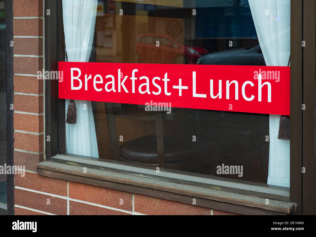 Ein Schild in einem Café-Fenster, auf dem ein komplettes Frühstück plus ...