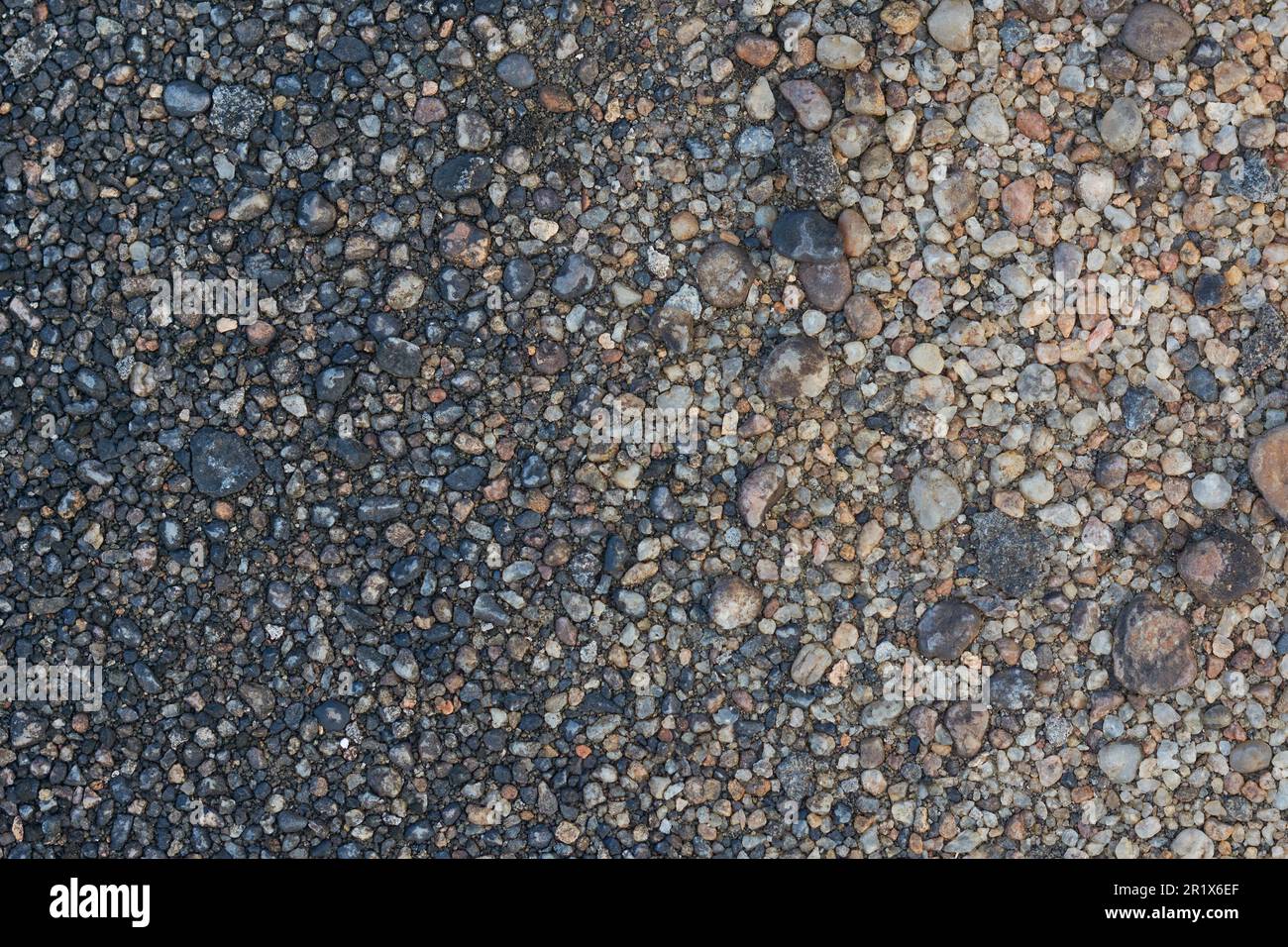Nahaufnahme von kleinen Felsen, Bodenoberfläche, schwarzgrauem Straßenstein oder Kieselsteinen im Vollformat, Hintergrundstruktur Stockfoto