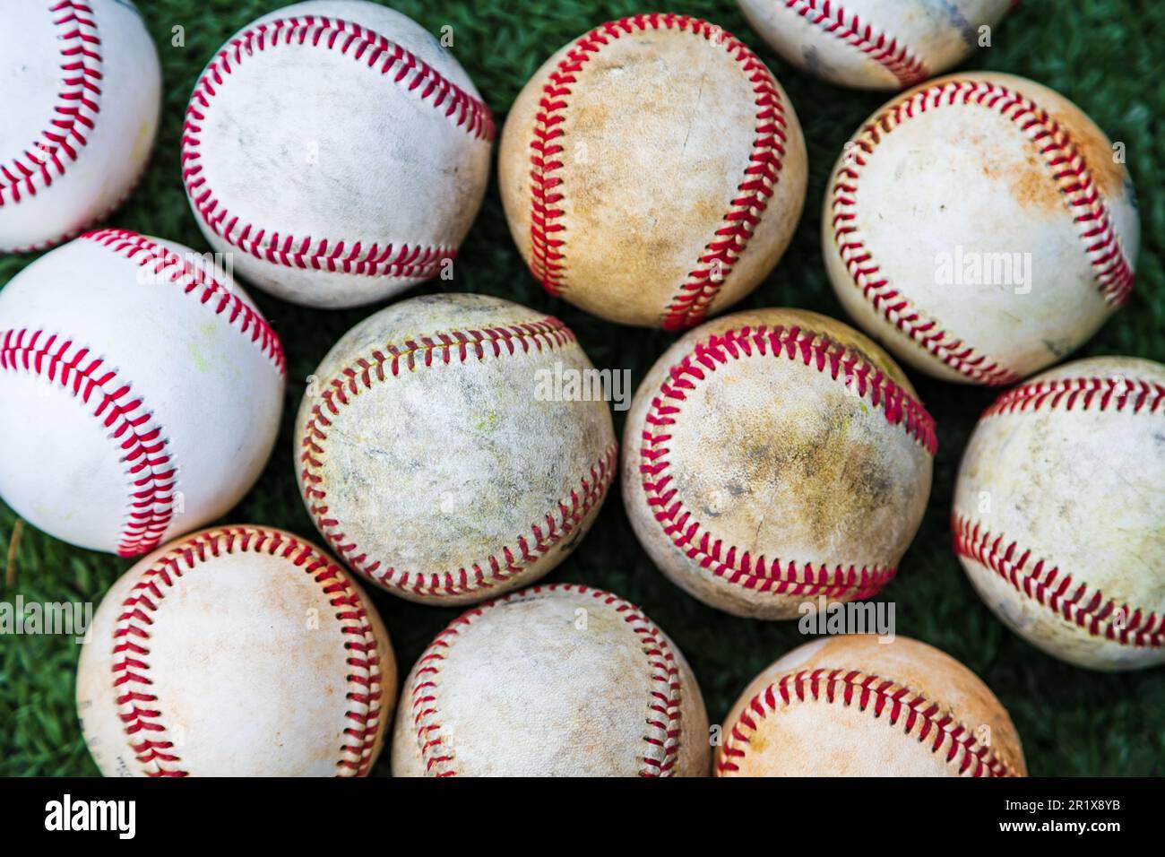 Sammlung gebrauchter Baseballbälle auf dem Boden für sportlichen Hintergrund Stockfoto
