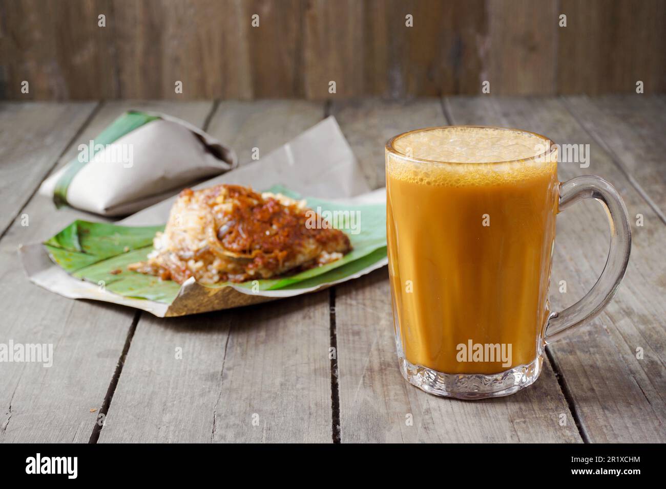 Ein beliebtes Frühstück in Malaysia ist ein heißes Getränk, Tee mit malaiischer Milch, genannt Teh Tarik, zum Essen mit Nasi Lemak Bungkus Stockfoto