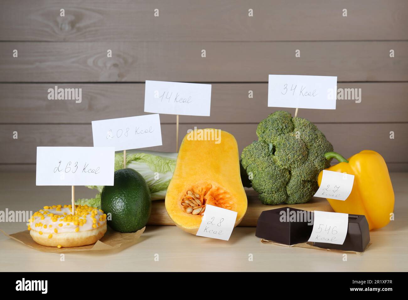 Lebensmittelprodukte mit Heizwertanhängern auf Holztischen. Gewichtsverlust-Konzept Stockfoto