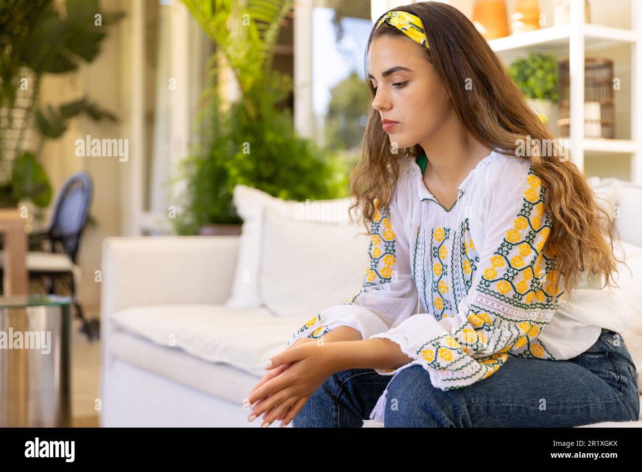 Besorgte, traurige weiße Frau, die auf dem Sofa im Wohnzimmer sitzt und denkt, Kopierraum Stockfoto