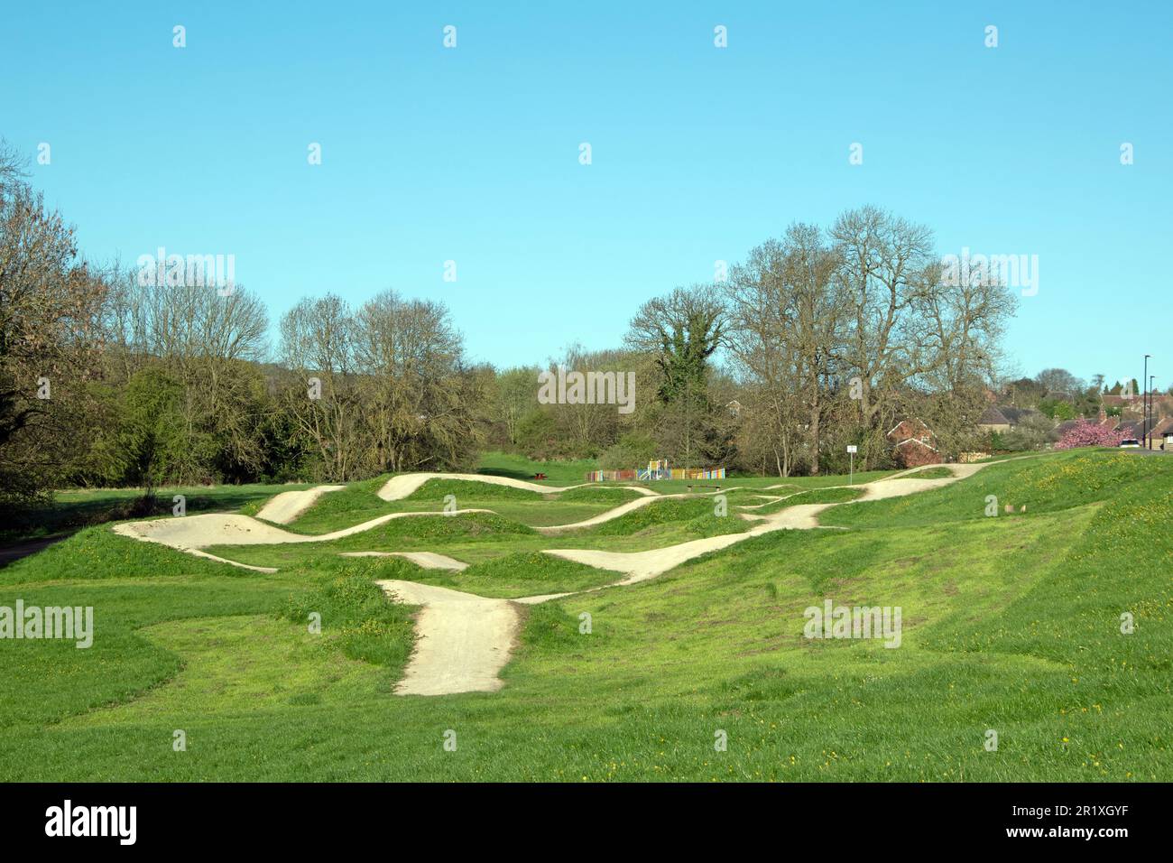 Fahrrad- und bmx-Pumptrack auf einem Feld mit Bäumen an einem Frühlingstag Stockfoto