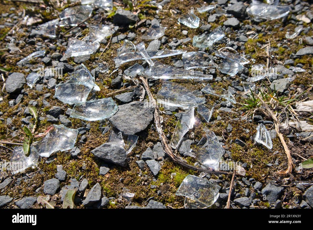 Zertrümmertes Glas, das auf dem Boden verstreut ist Stockfoto