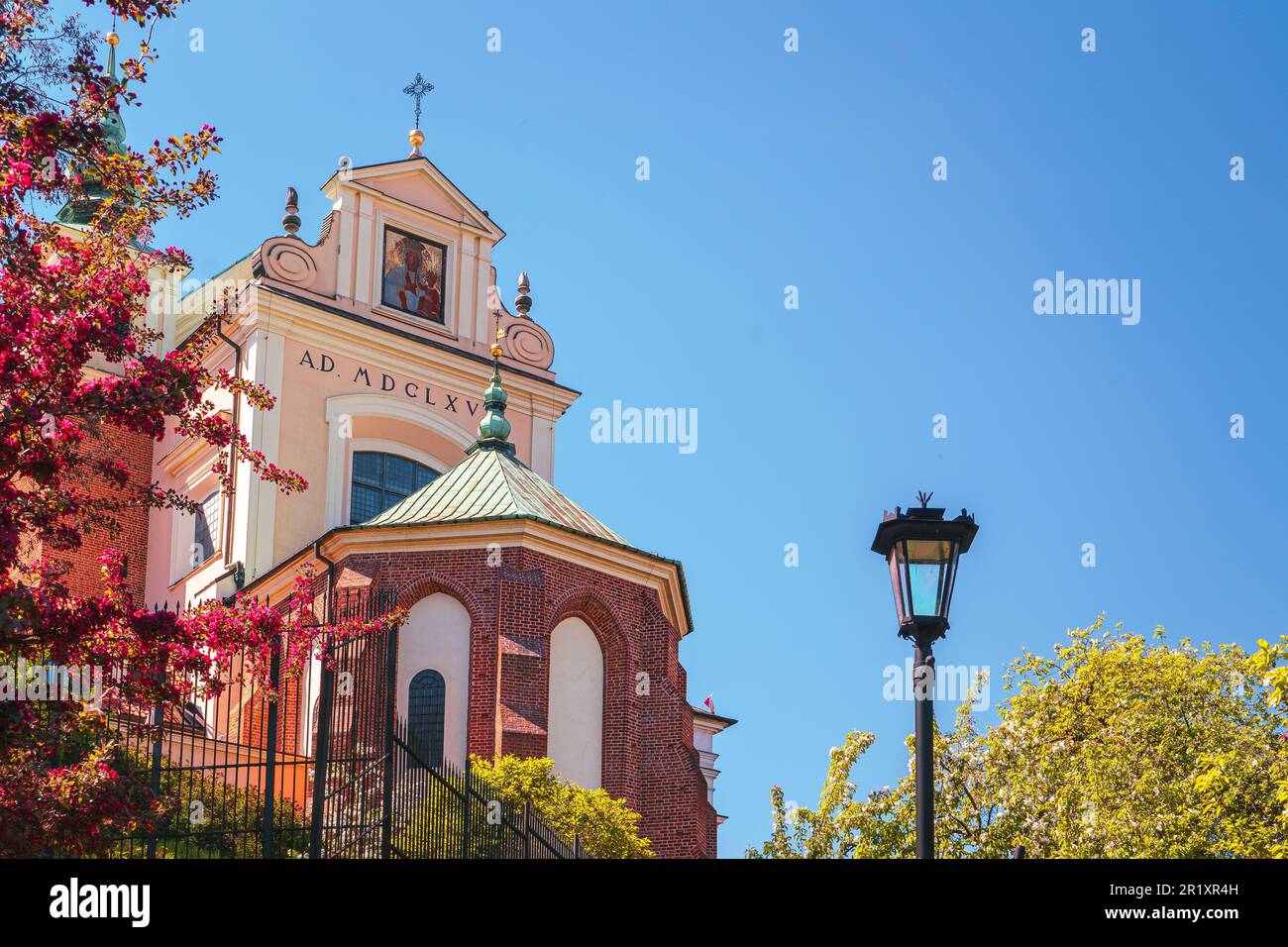 Katholische Kirche St. Anna in Warschau. Blick von der Ostseite, blühendes Flieder im Hintergrund Stockfoto